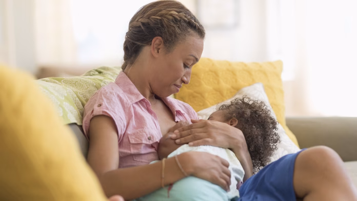 Aleitamento materno em foco com mãe amamentando bebê nos primeiros meses de vida