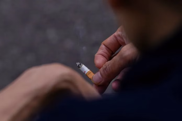 Cigarro aceso em cinzeiro, símbolo dos riscos do tabagismo para pulmões e coração