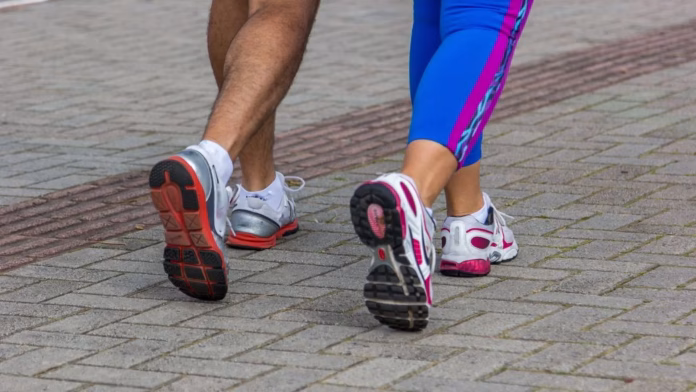 Pessoa caminhando em rua urbana, imagem associada a atividade física e sedentarismo