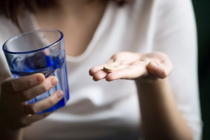 Pessoa segurando caixas de medicamentos para depressão e ansiedade, com destaque para a Geração Z